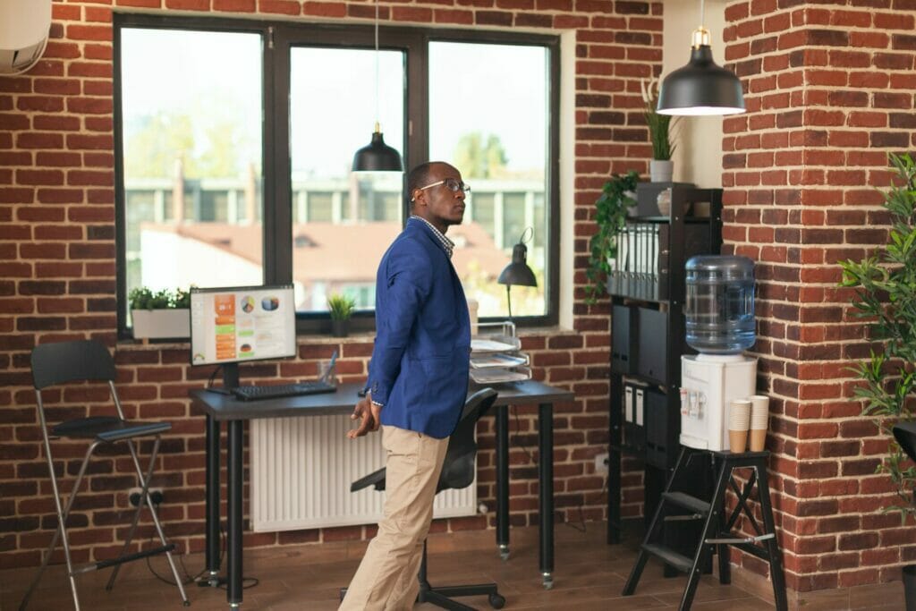 Pensive man standing in company office to think about business strategy and innovation