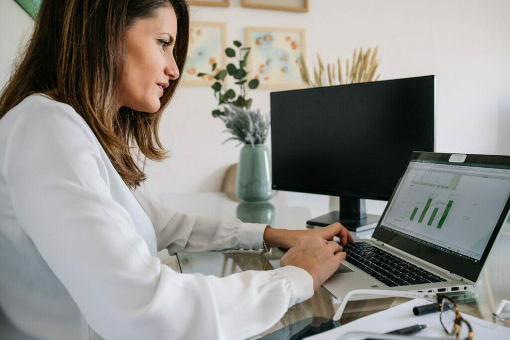 Female remote employee preparing report on laptop