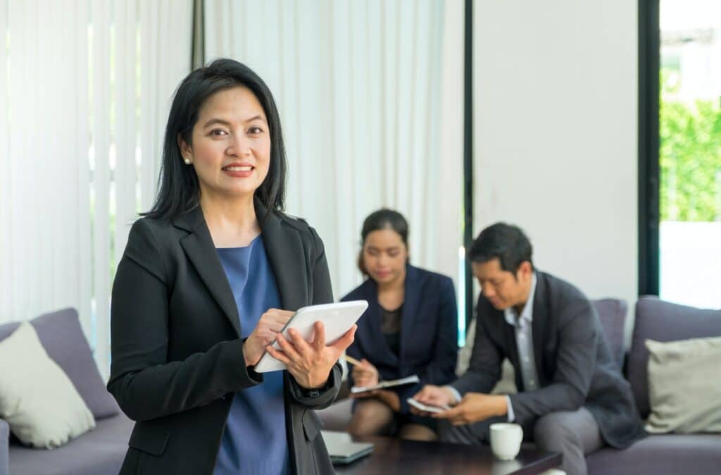 Businesswoman leader using tablet with team in corporate meeting at office,Female leadership concept