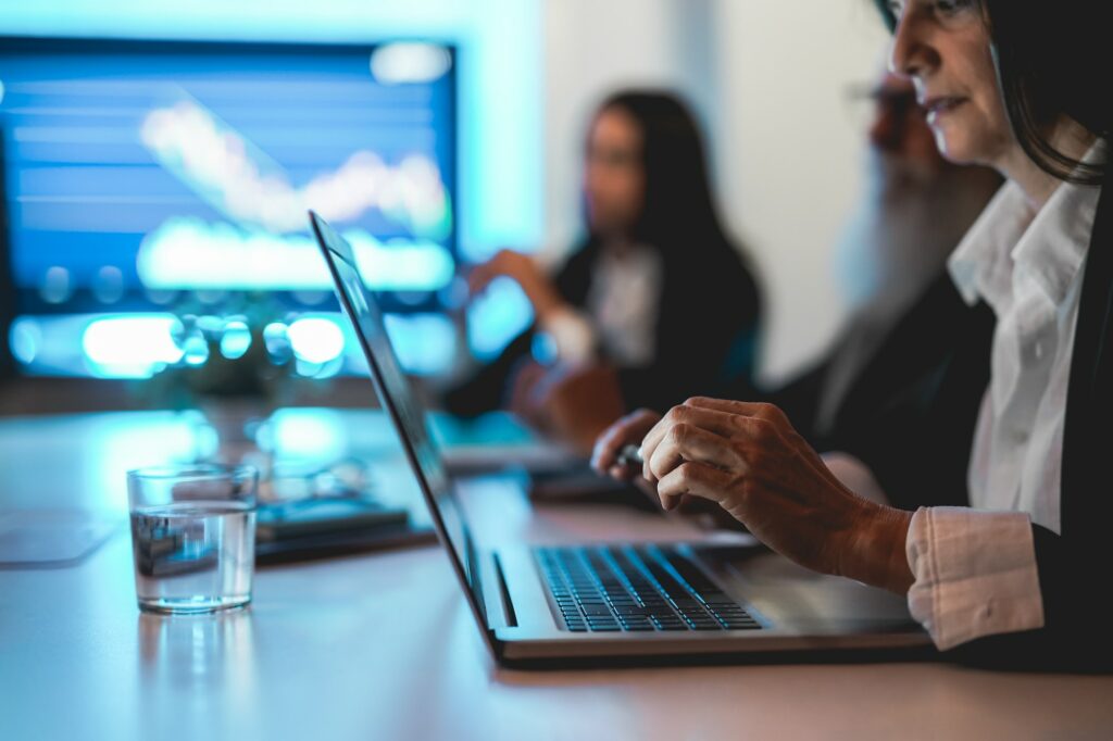 Business team worker doing stock market analysis inside hedge fund office - Focus on woman hand