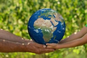 Senior man and child holding Earth planet. Elements of this image furnished by NASA