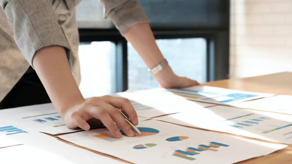 close up businesswoman holding pen point graph chart for profit forecast in this year.