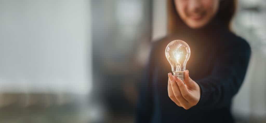 Hand holding light bulb with the light new mindset in of the bright light