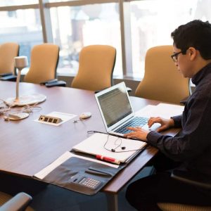 man uses laptop at the conference table