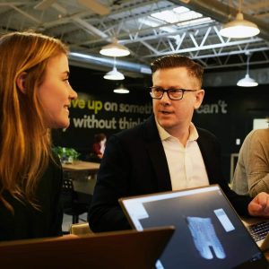 Photo by LinkedIn Sales Solutions man and two women sitting beside table